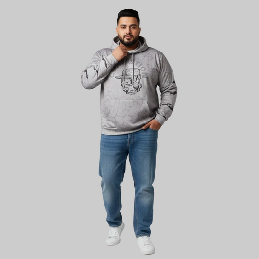 Man wearing a gray hoodie and blue jeans on a light gray background