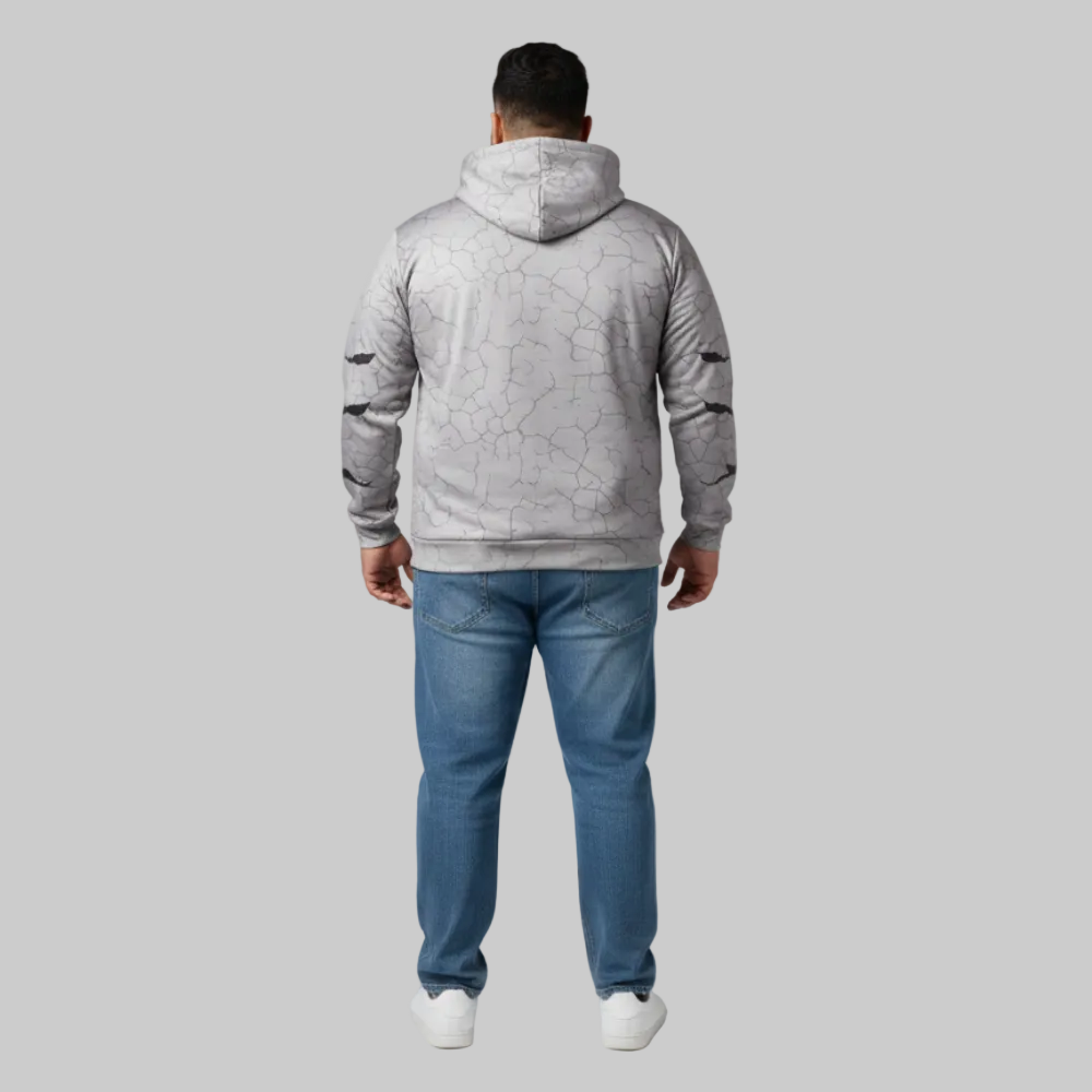 Person wearing a gray textured hoodie and blue jeans on a light gray background