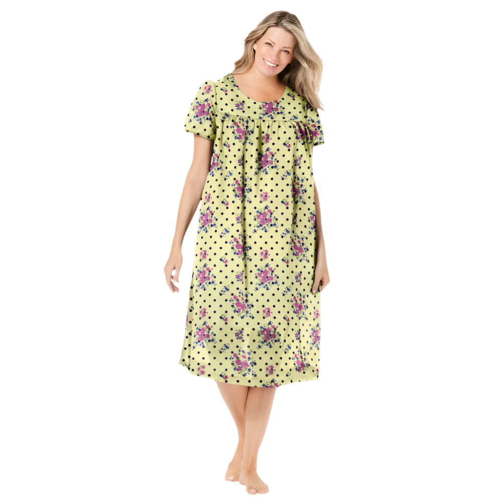 Plus-size woman wearing a short-sleeve, mid-length lounger with a banana dot floral print, featuring a scoop neckline, shirred yoke, and side pockets.