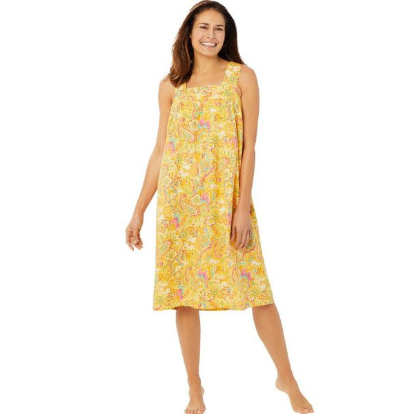Plus-size woman wearing a sleeveless, mid-length lounger with a banana-yellow paisley print, featuring a square neckline, shirred yoke, and side pockets.