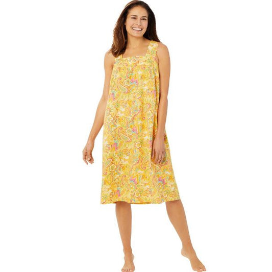 Plus-size woman wearing a sleeveless, mid-length lounger with a banana-yellow paisley print, featuring a square neckline, shirred yoke, and side pockets.
