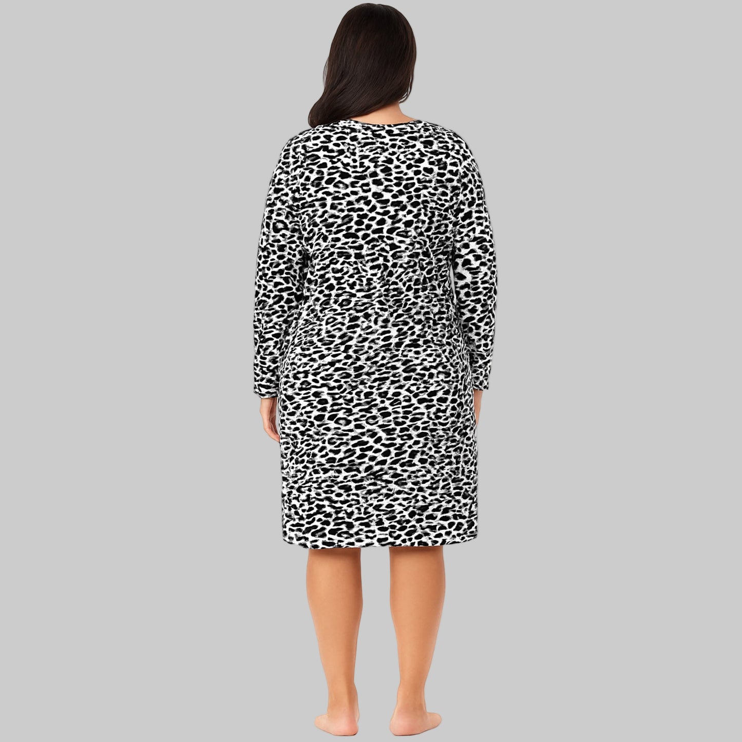 Plus-size woman wearing a black abstract printed long-sleeve cotton sleepshirt, standing barefoot on a white background.