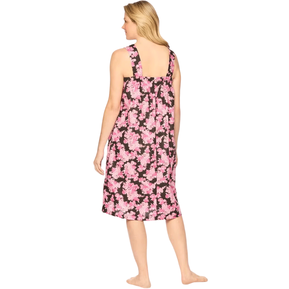 Plus-size woman wearing a sleeveless, mid-length lounger with a black camellia floral print, featuring a square neckline, shirred yoke, and side pockets.