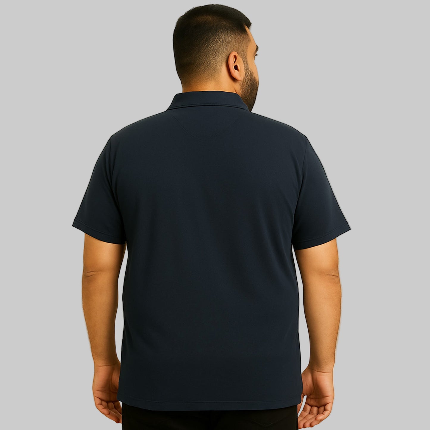 Plus-size Pakistani male model wearing black cotton polo shirt with horn buttons and chest pocket on a studio background.