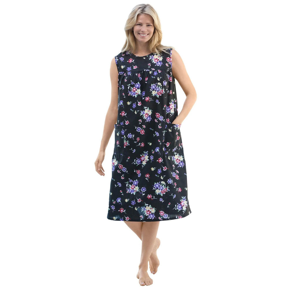 Plus-size woman wearing a sleeveless, mid-length lounger with a black tossed floral print, featuring shirred front and back yokes and front patch pockets.