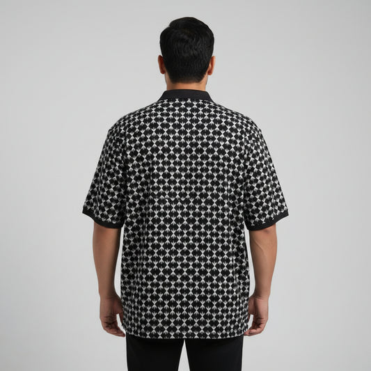 Black plus size polo shirt with white geometric print and solid black collar laid flat showing full front design