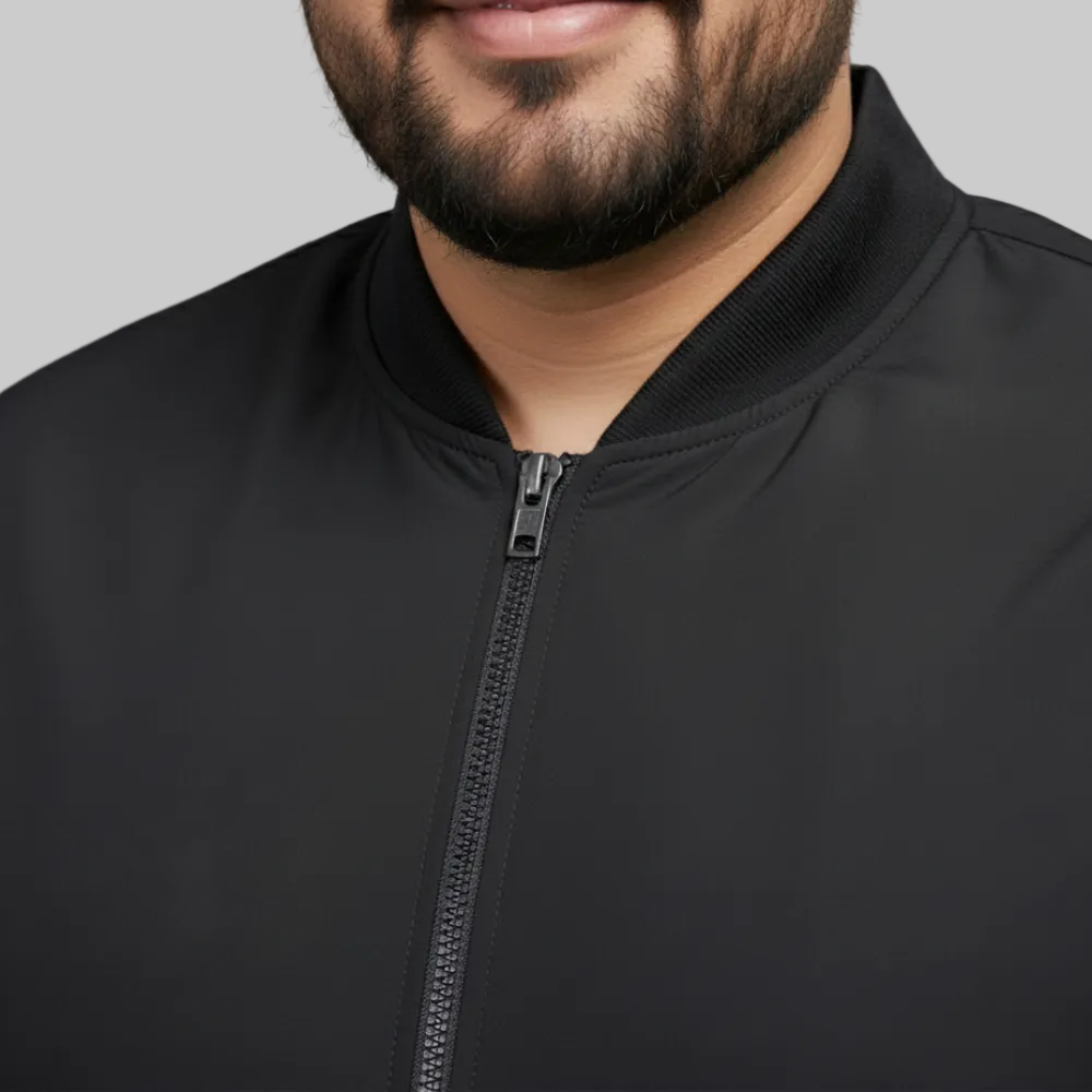 Black plus size bomber jacket with front zip closure and ribbed cuffs displayed on a plain background.