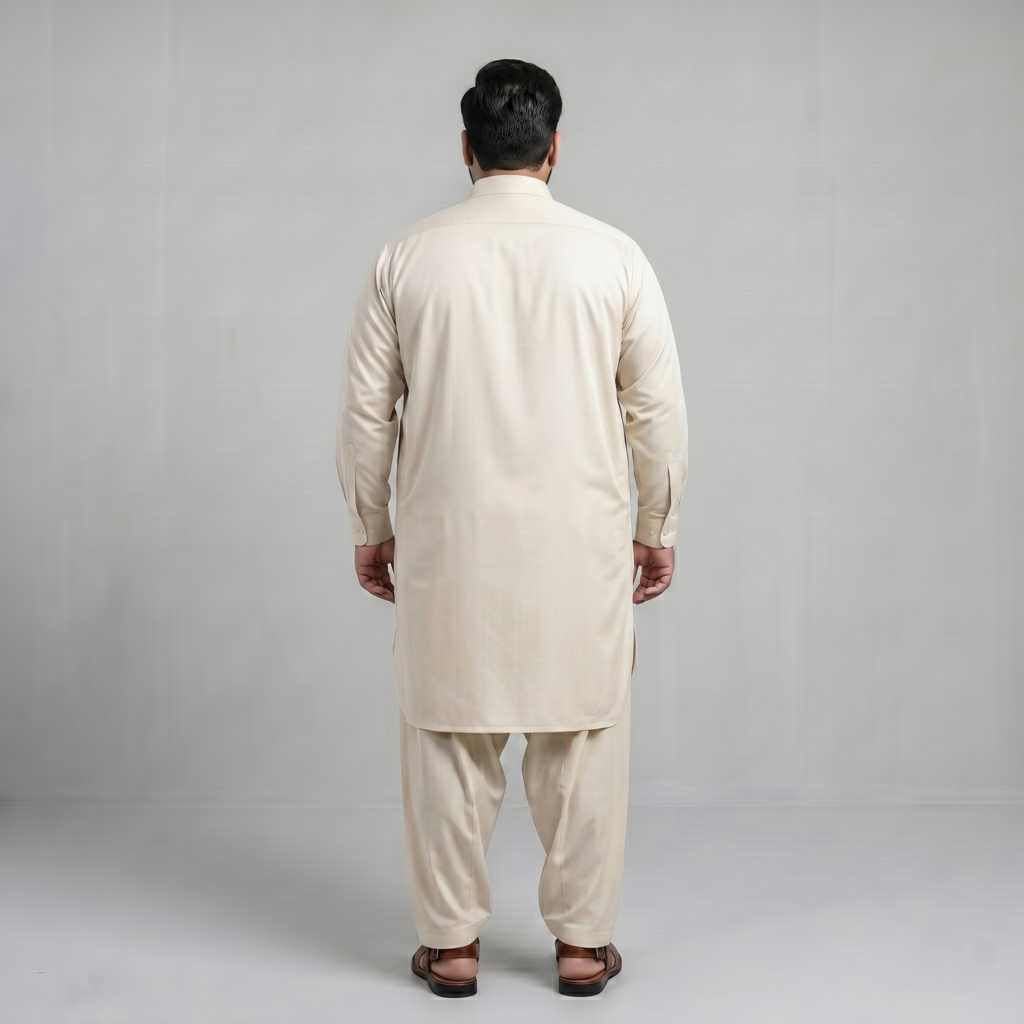 Man wearing a beige kurta set against a plain background
