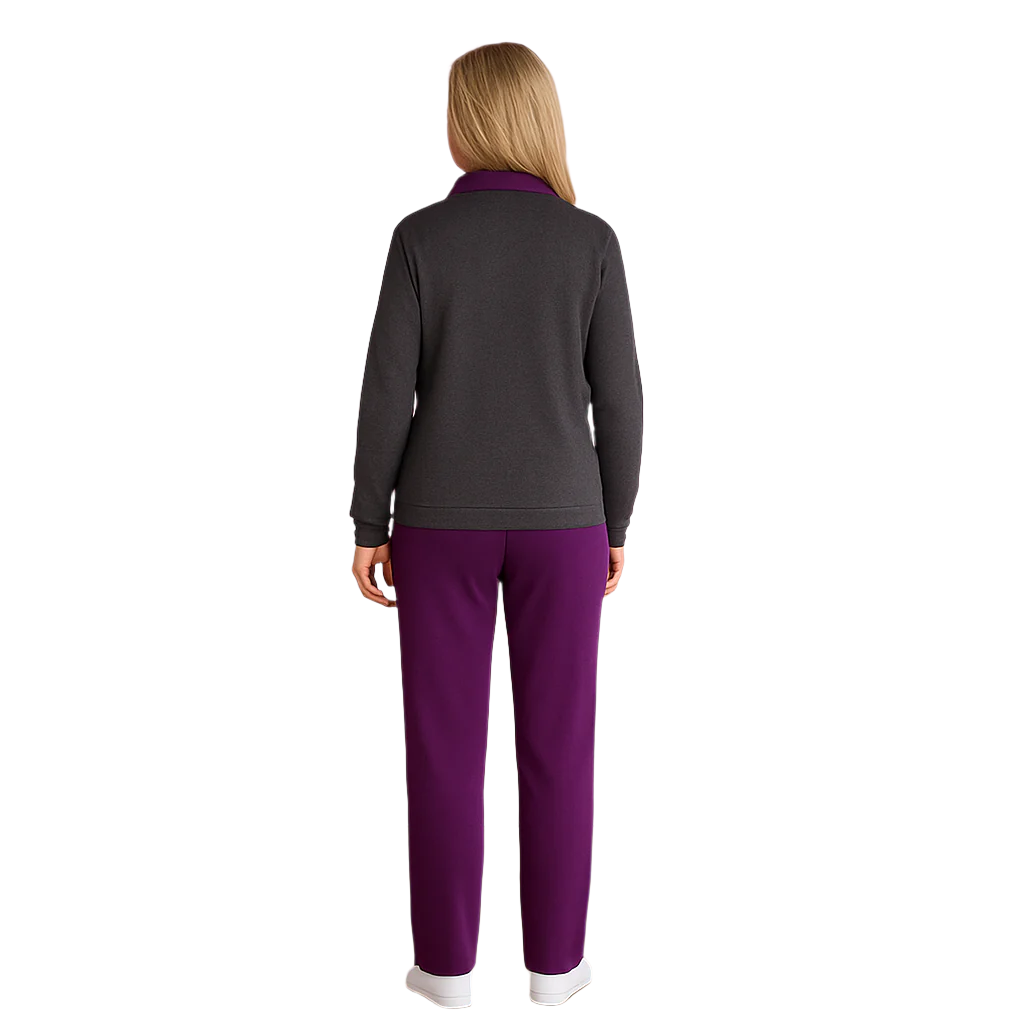 Plus size woman wearing a charcoal zip-front fleece pullover with purple collar and matching purple lounge pants, standing indoors in a relaxed pose.