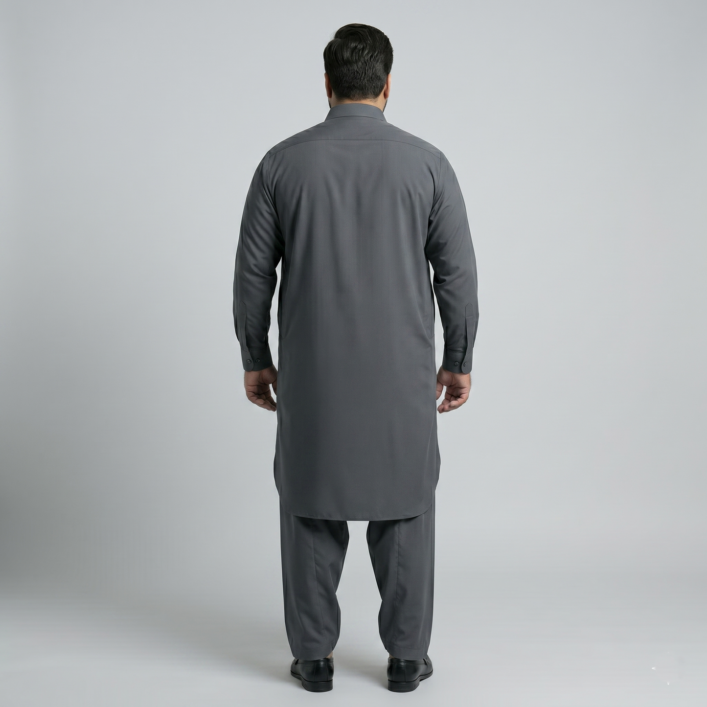 Man wearing a gray traditional outfit on a plain background