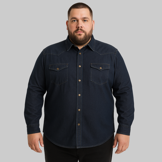 Plus-size male model wearing a dark indigo denim western shirt with chest pockets, button-down front, and long sleeves, studio shot on a clean white background.