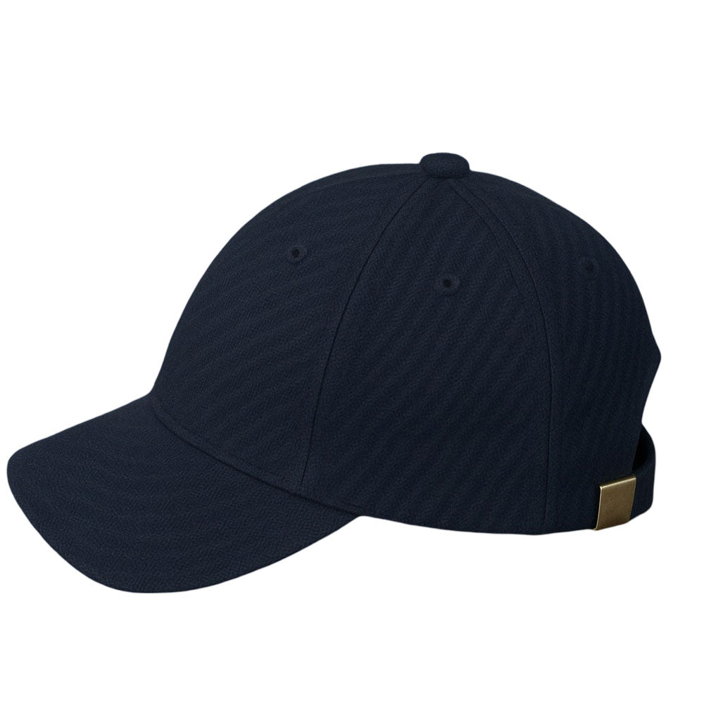 Classic navy blue textured baseball cap with silver buckle strap on wooden surface.