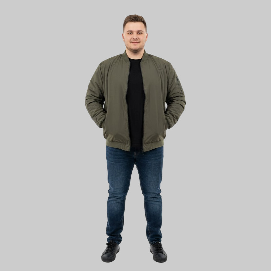 Plus-size male model wearing a classic olive bomber jacket with ribbed cuffs, collar, and hem – front view, hands in pockets.