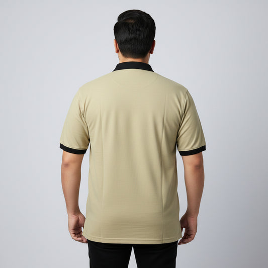 Alt Text: Men's classic beige short-sleeve polo shirt featuring a black contrast collar and ribbed sleeve trims, laid flat on a white surface.