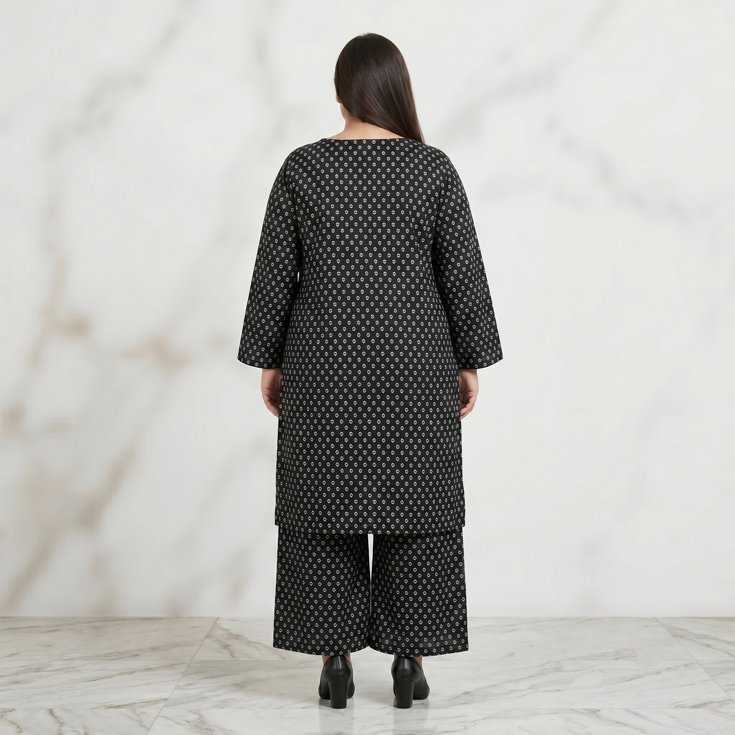 Woman wearing a black patterned outfit against a white background
