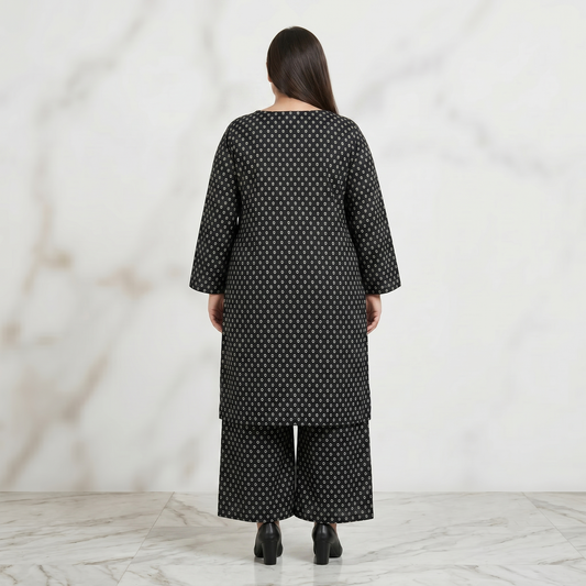 Woman wearing a black patterned outfit against a white background