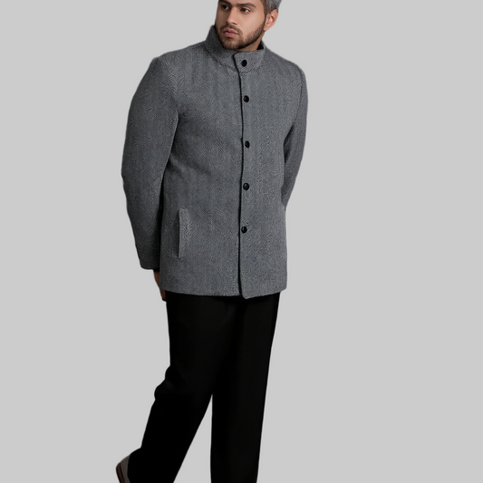 Man wearing a gray coat against a dark background