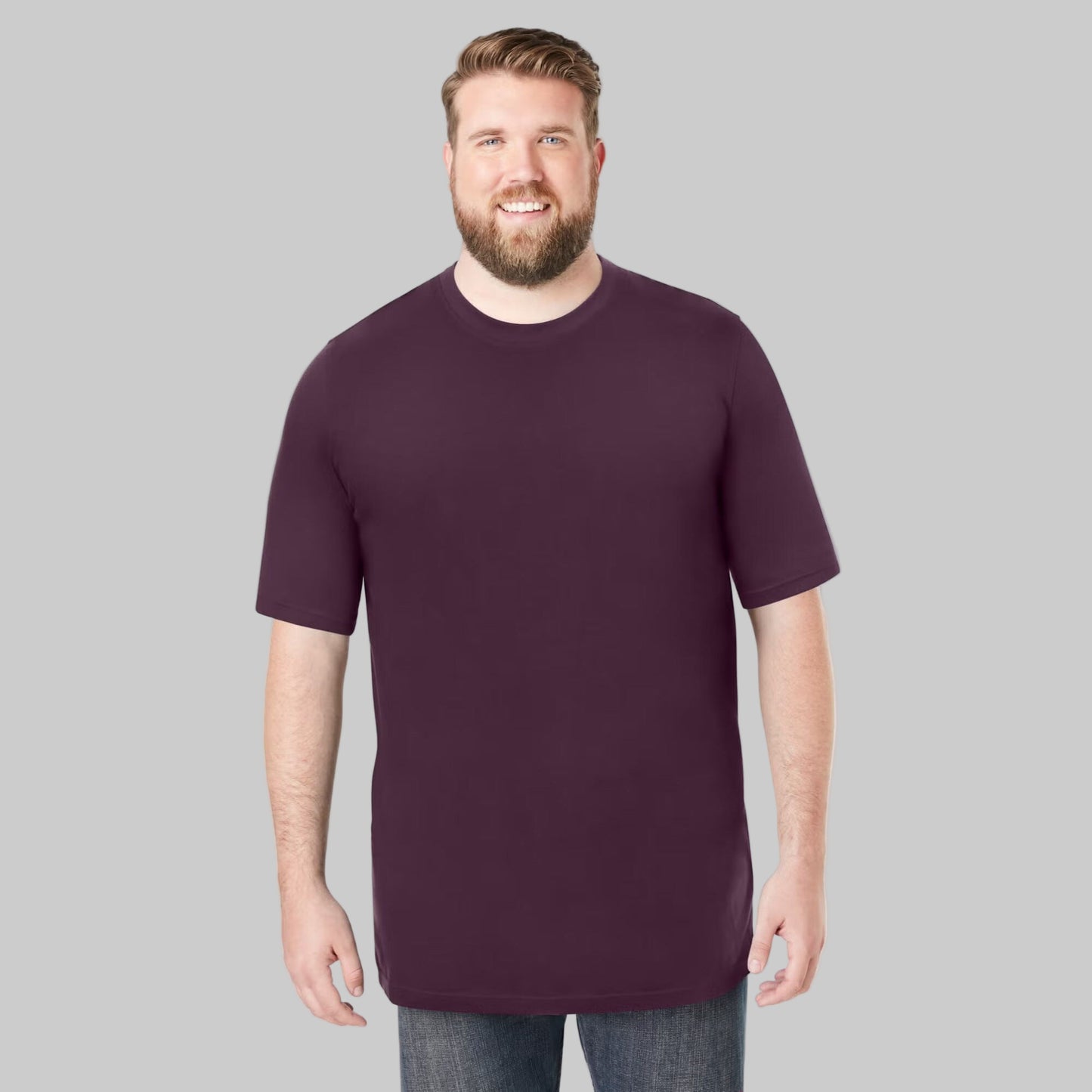 Plus-size male model wearing deep purple heavyweight crewneck T-shirt, relaxed fit, front view, studio background.