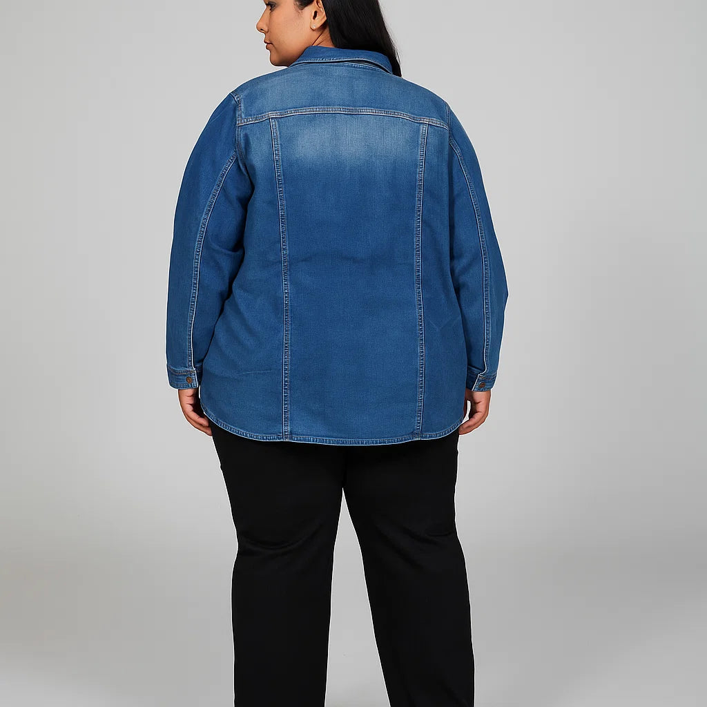 Plus-size woman wearing a light indigo longline utility denim jacket with front buttons and chest pockets