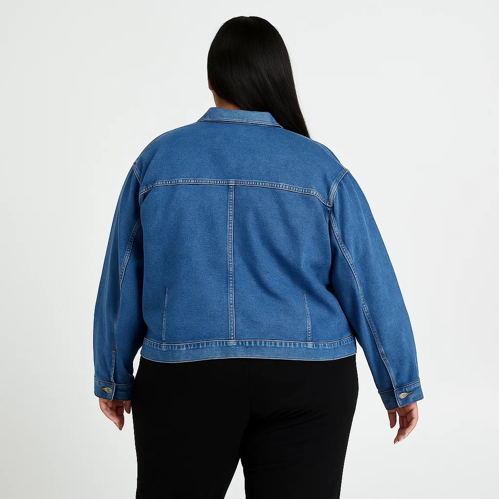 Plus-size woman wearing a soft indigo denim jacket with chest pockets and button-down front