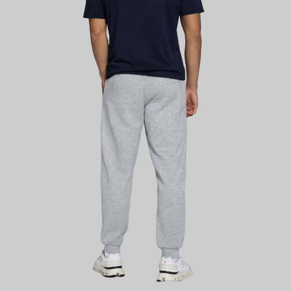 Heather grey fleecejogger pants with elastic waistband and ribbed ankle cuffs, worn by a model for casual everyday comfort.