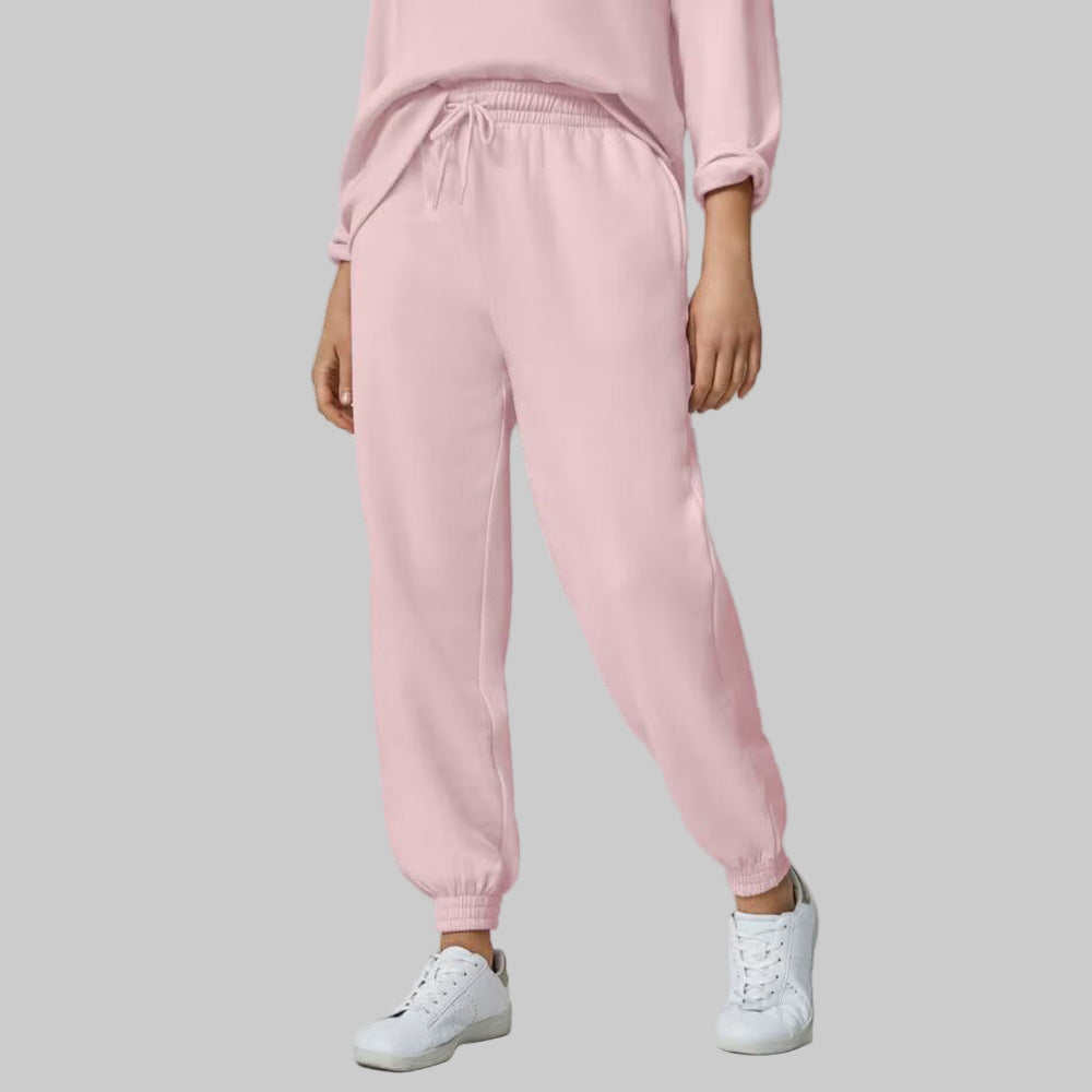 Plus-size woman wearing Misty Rose fleece jogger sweatpants with drawstring waist and elastic cuffs, styled with side pockets.