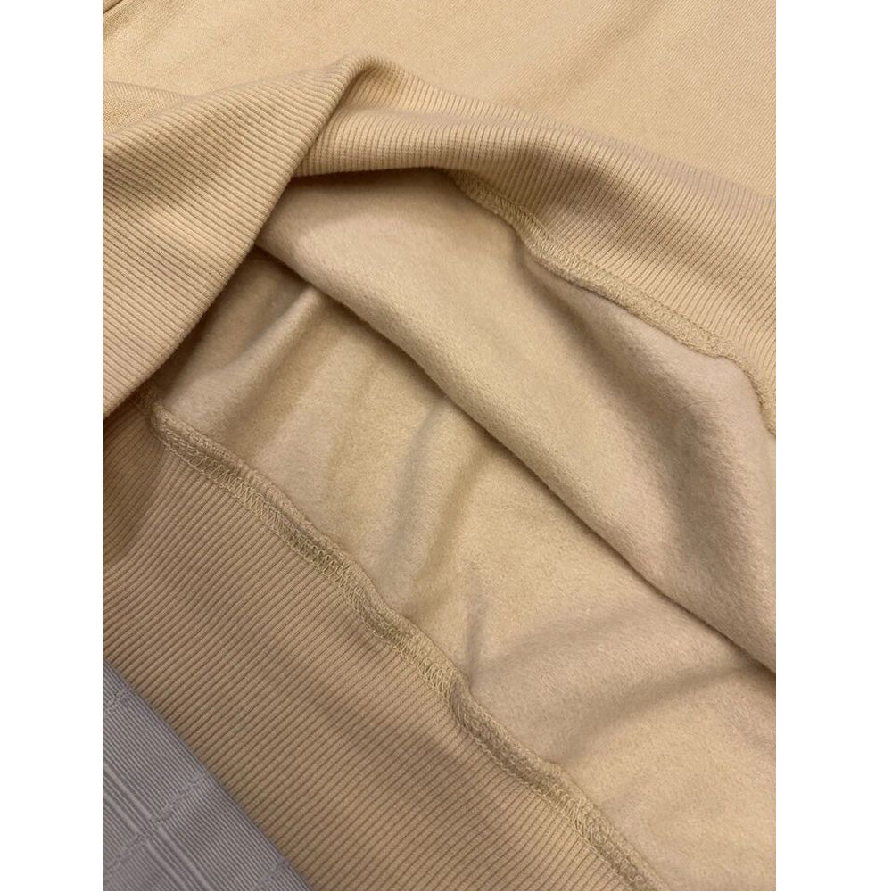 Close-up of fleece texture and ribbed crew neckline in oat tan sweatshirt
