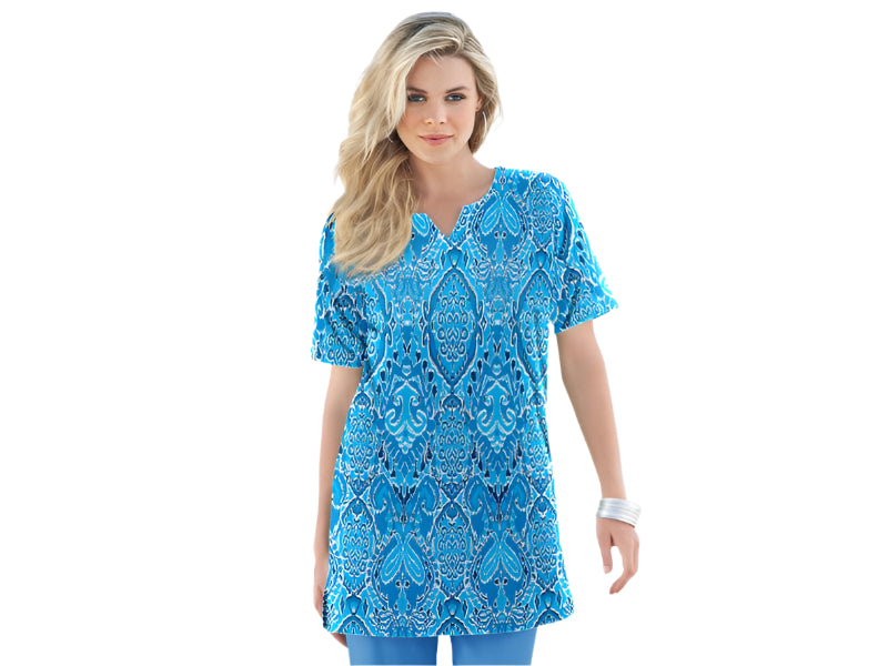 Plus-size women’s tunic in a bold ocean blue ikat print with a notch neckline and soft knit fabric, displayed on a mannequin.