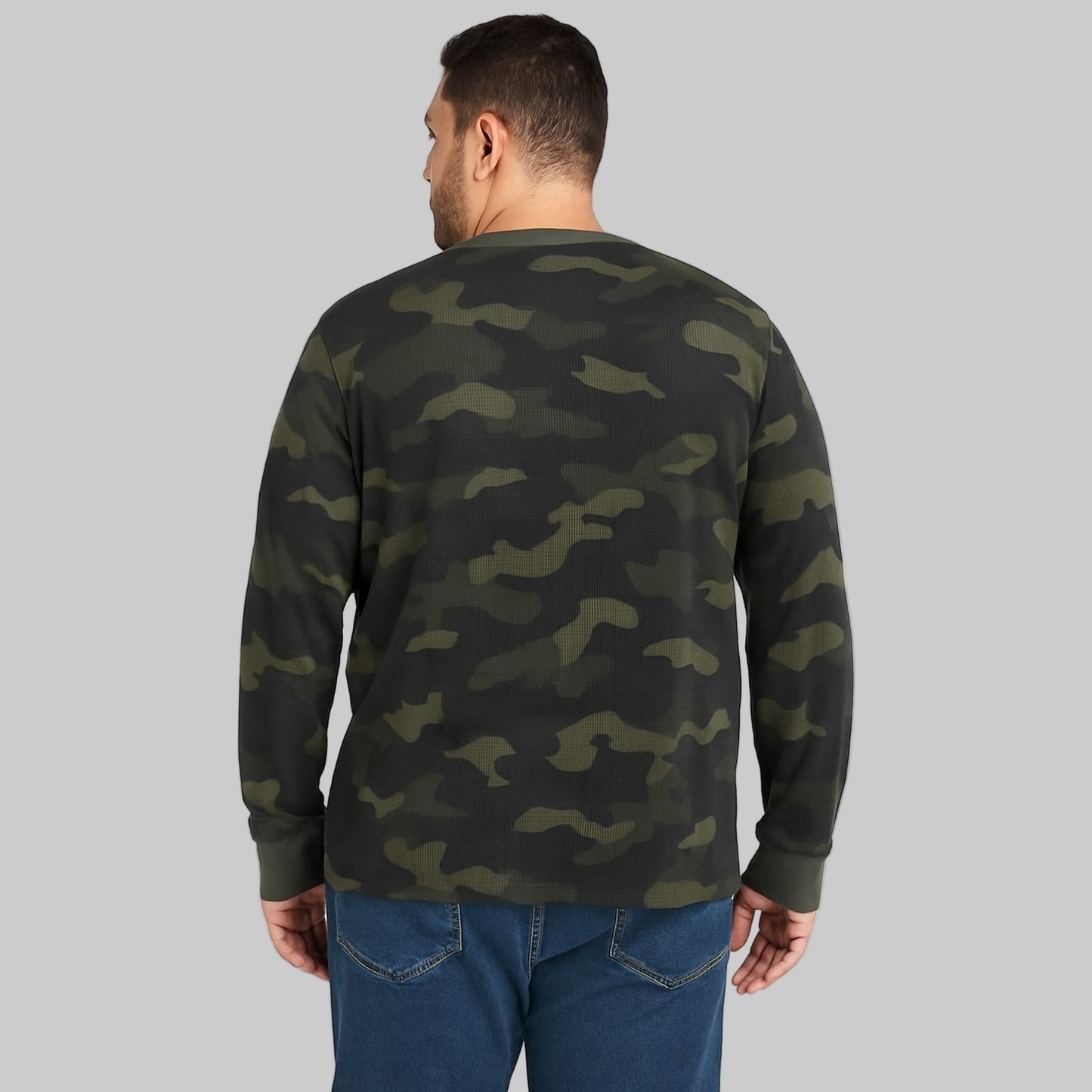 Plus-size Pakistani male model wearing olive camo waffle-knit thermal Henley tee, long sleeves, front view on studio background.