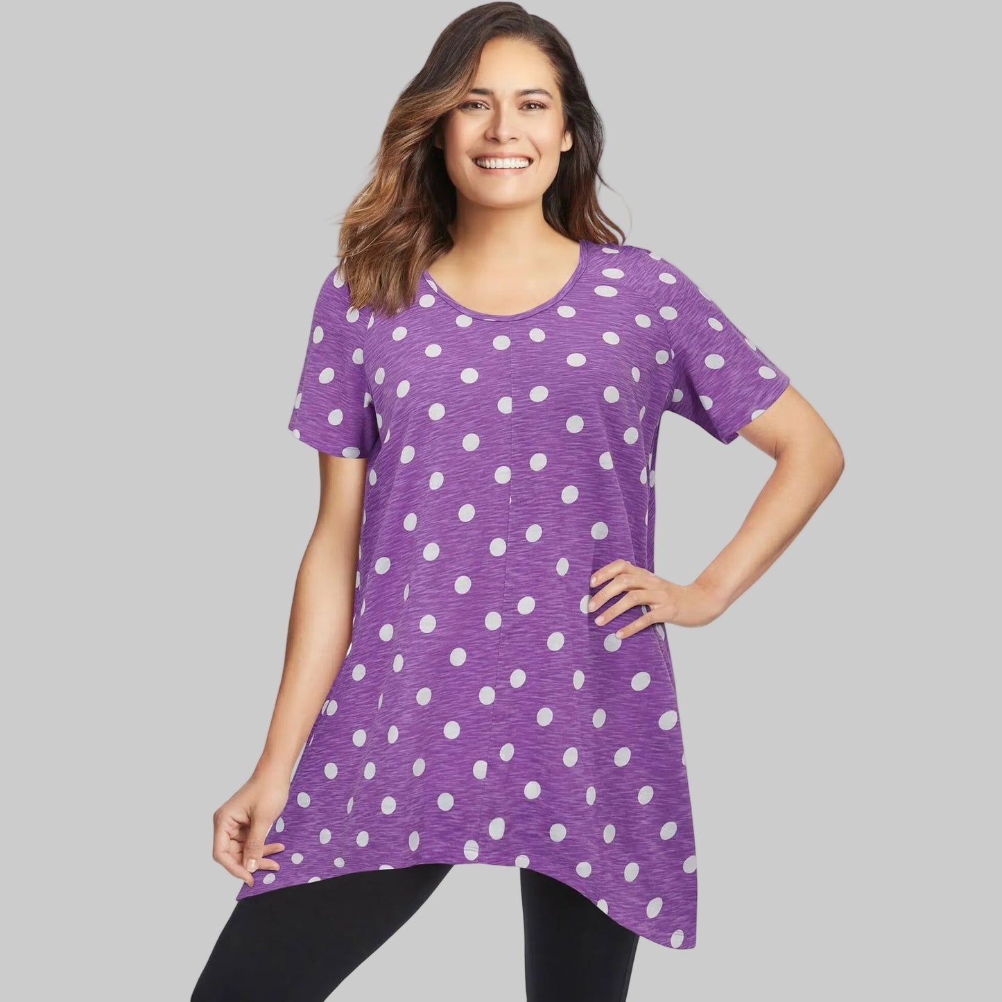 Plus size violet tunic with white polka dots, scoop neck, short sleeves, and pointed hem – relaxed cotton top for women