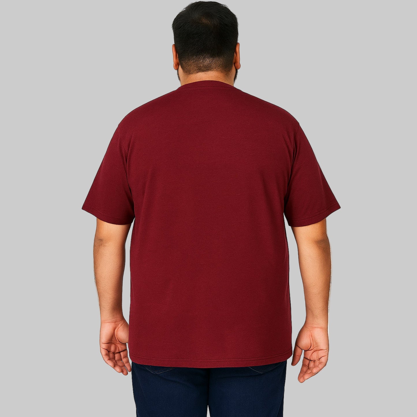 Plus-size Pakistani male model wearing rich burgundy Henley T-shirt on a light studio background, relaxed fit, 4-button placket.