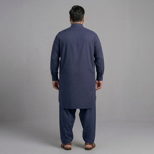 Man wearing a navy blue kurta set against a gray background