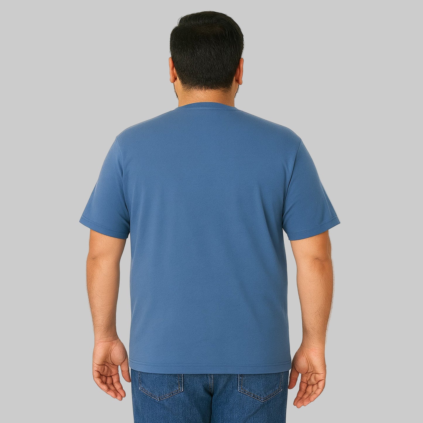 Plus-size Pakistani male model wearing slate blue crewneck T-shirt on a clean studio background, relaxed fit.