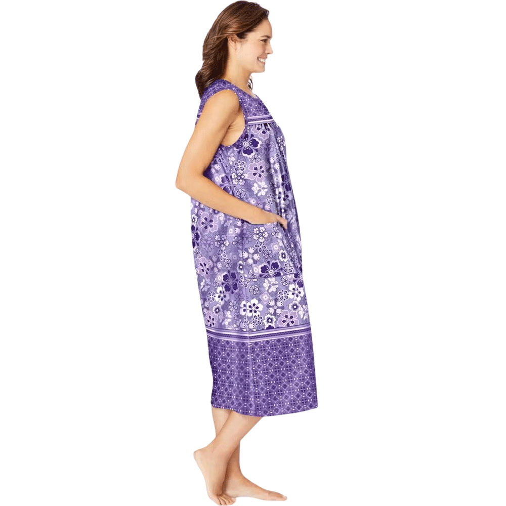 Plus-size woman wearing a sleeveless, mid-length lounger with a soft iris pansy floral print, featuring shirred front and back yokes and front patch pockets.