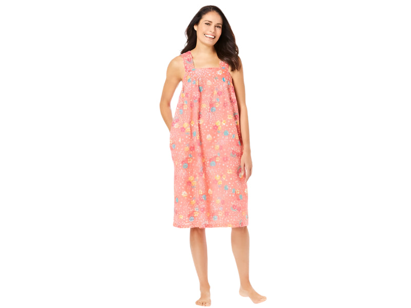 Plus-size woman wearing a sleeveless, mid-length lounger with a sweet coral floral print, featuring a square neckline, shirred yoke, and side pockets.