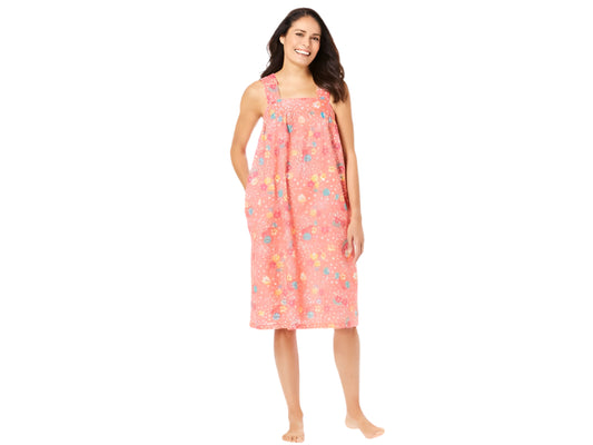 Plus-size woman wearing a sleeveless, mid-length lounger with a sweet coral floral print, featuring a square neckline, shirred yoke, and side pockets.