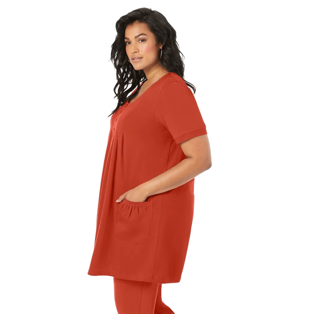 A woman wearing a Rust Orange Two Pocket Soft Knit Tunic with short sleeves, a scoop neckline, and two front pockets, styled with jeans for a casual look.