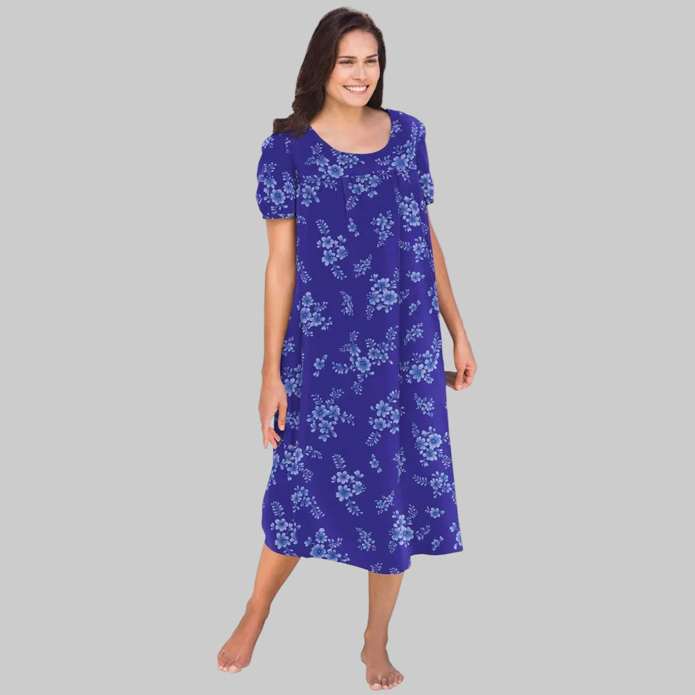 Plus-size woman wearing a short-sleeve, mid-length lounger with an ultra-blue floral bouquet print, featuring shirred front and back yokes and side seam pockets.