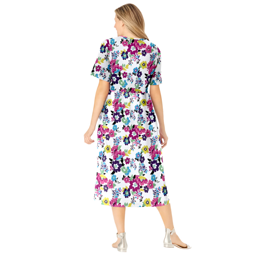 Woman wearing white floral garden print button-front dress with elbow sleeves and flowing skirt
