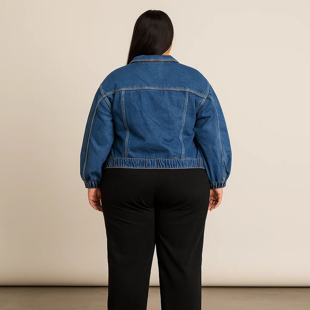 Plus-size woman wearing classic blue denim jacket with elastic hem and button-front