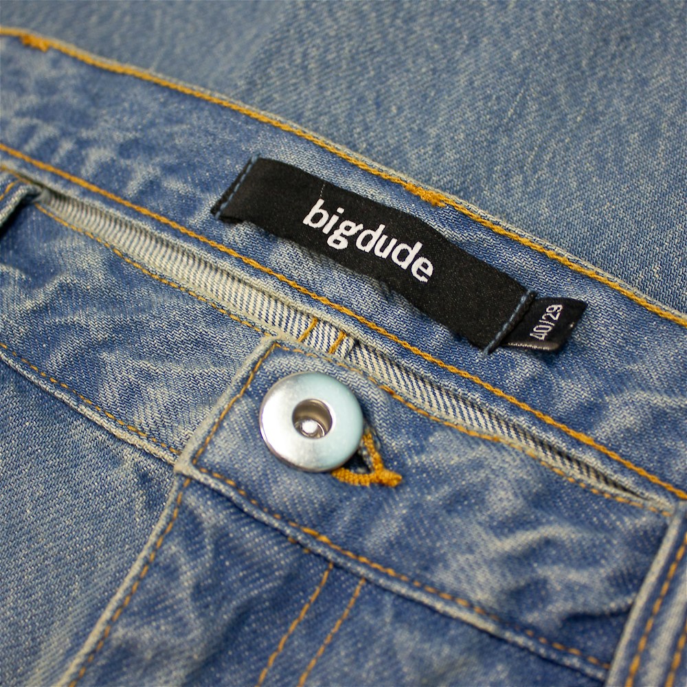 Plus-size men’s stone wash blue regular fit jeans with straight leg, button and zip fly, front and rear pockets, displayed on a clean white background.