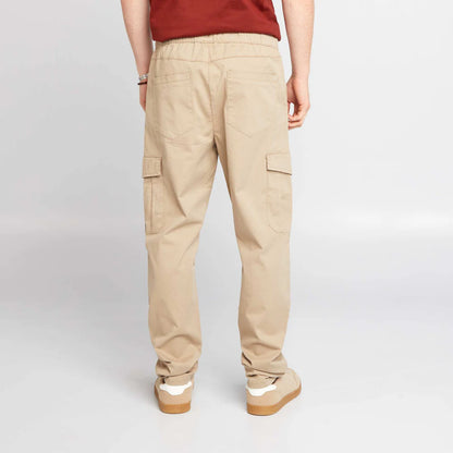 Men’s beige jogger pants with elasticated waist, side flap pockets, and elasticated ankles,