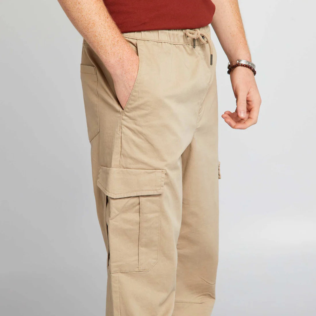 Men’s beige jogger pants with elasticated waist, side flap pockets, and elasticated ankles,
