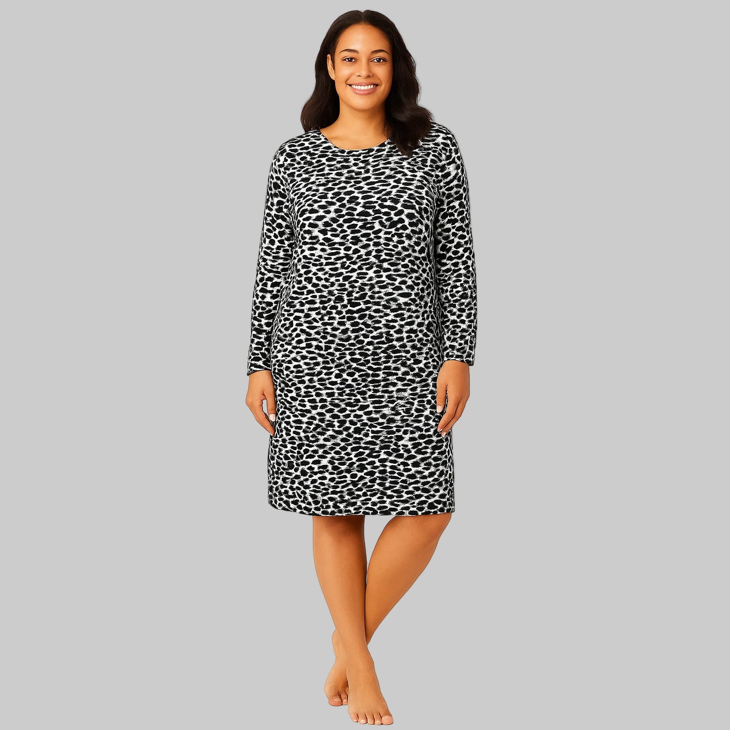 Plus-size woman wearing a black abstract printed long-sleeve cotton sleepshirt, standing barefoot on a white background.