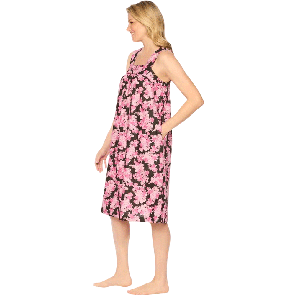 Plus-size woman wearing a sleeveless, mid-length lounger with a black camellia floral print, featuring a square neckline, shirred yoke, and side pockets.​

