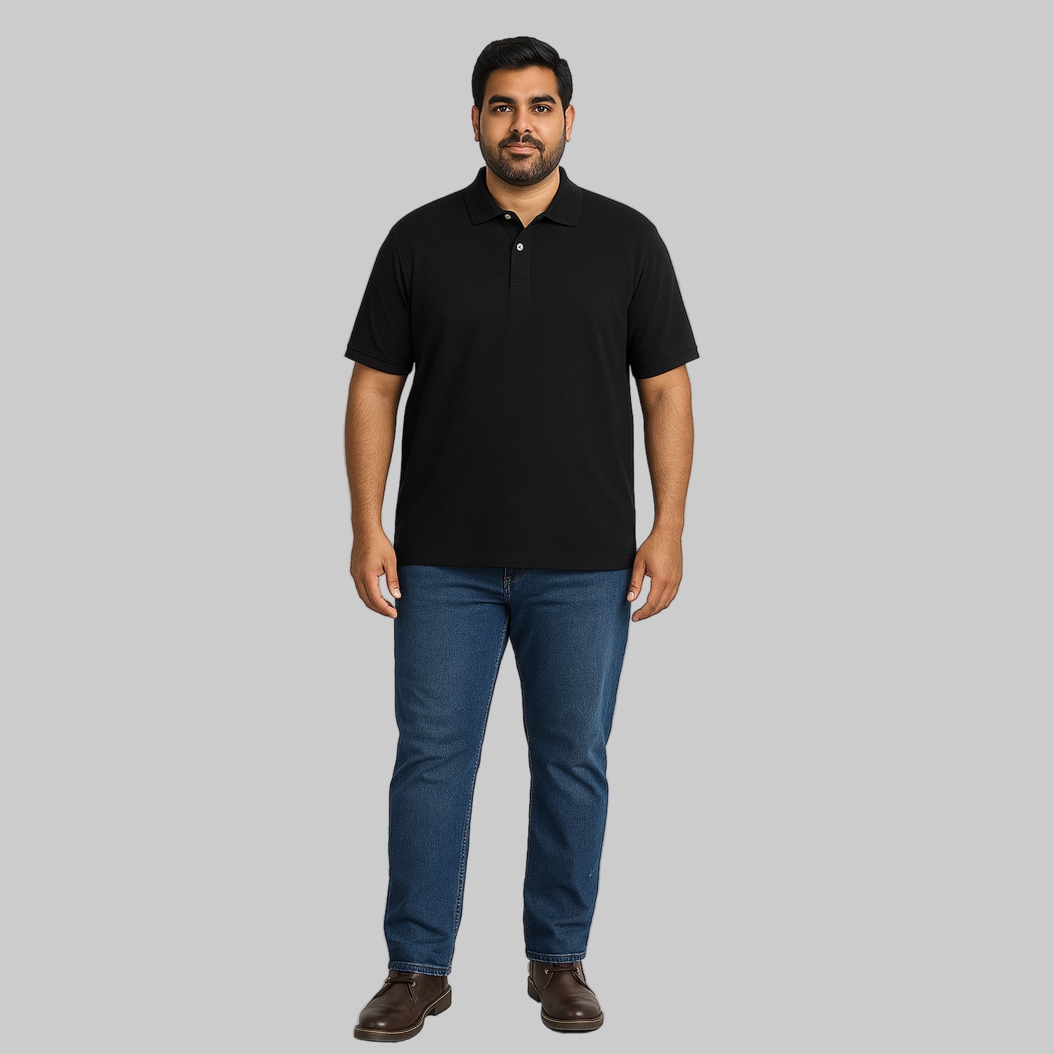 Plus-size Pakistani male model wearing black piqué polo shirt with dark jeans on a light studio background, relaxed fit.
