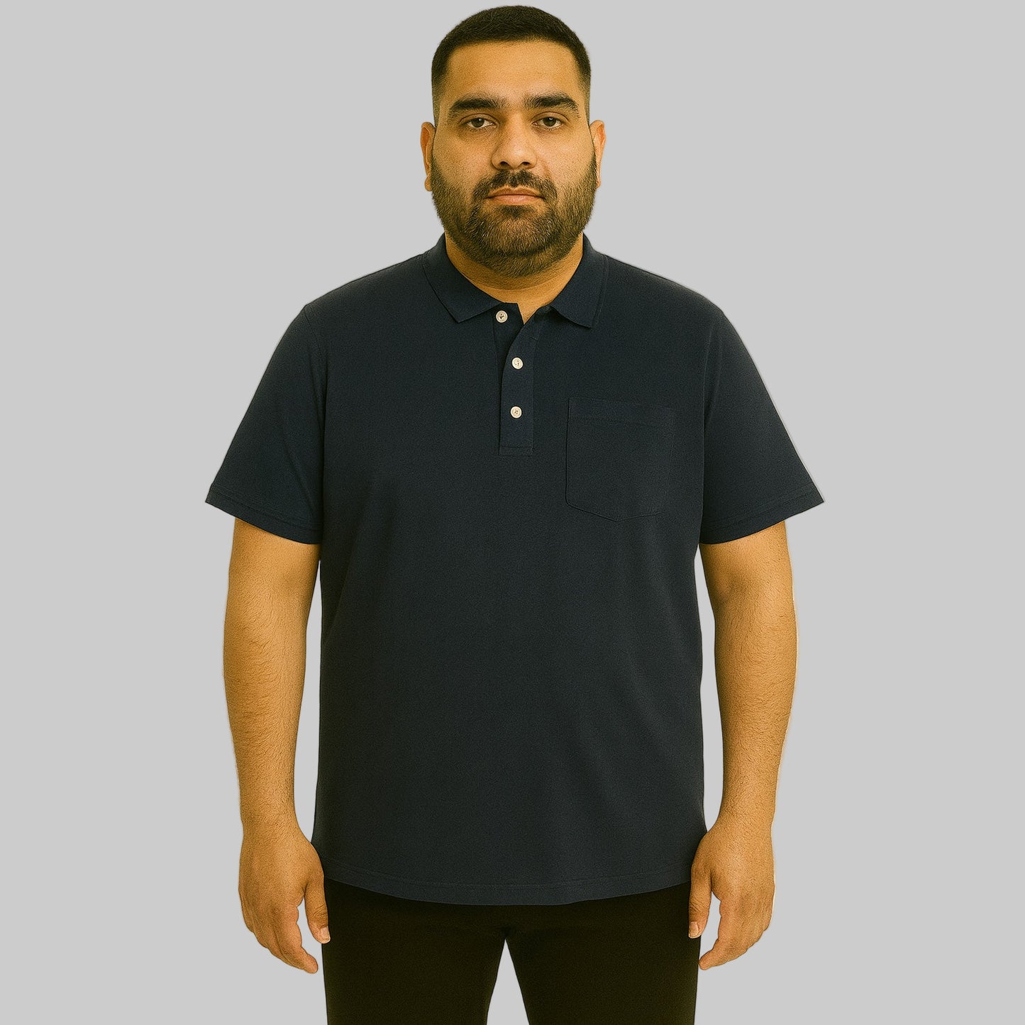 Plus-size Pakistani male model wearing black cotton polo shirt with horn buttons and chest pocket on a studio background.