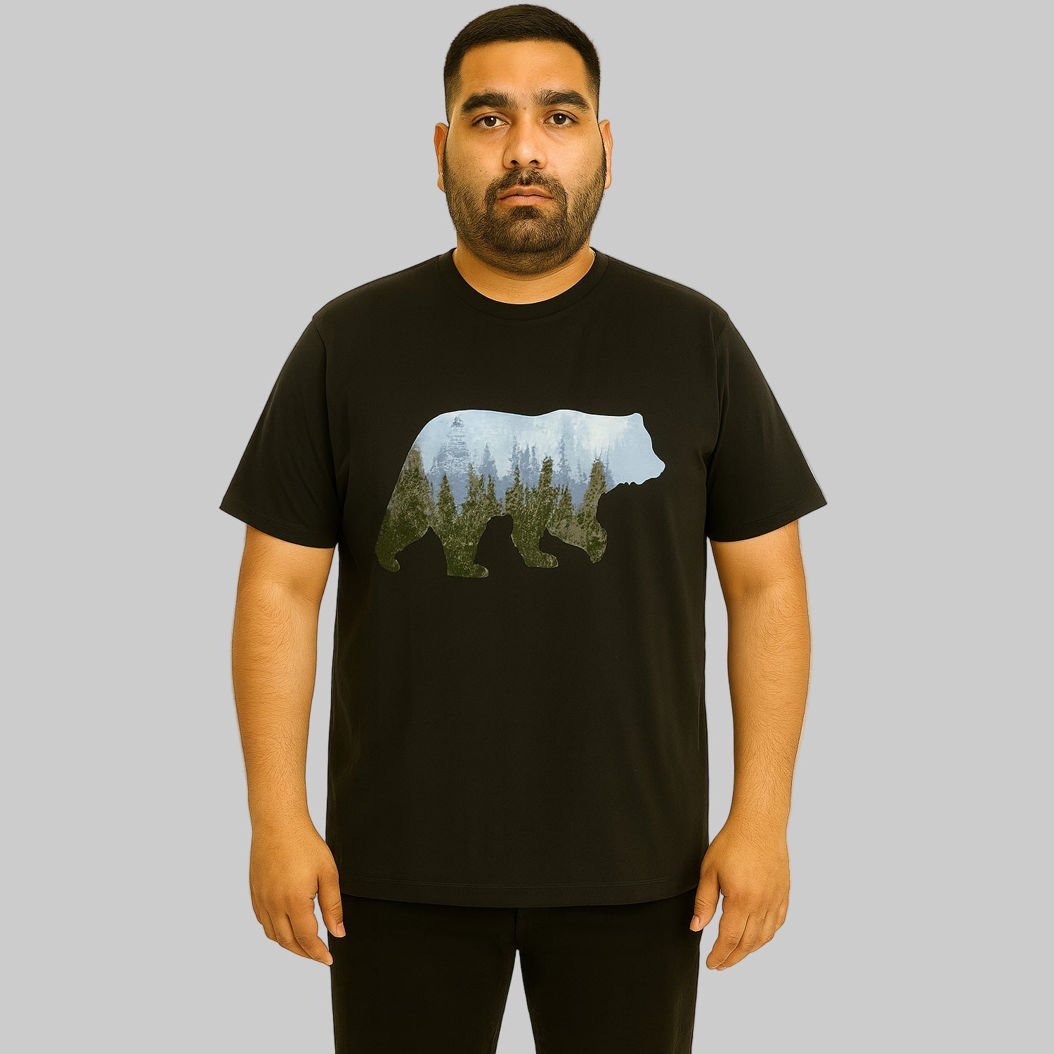 Plus-size Pakistani male model wearing black nature graphic T-shirt with relaxed fit on a clean studio background.