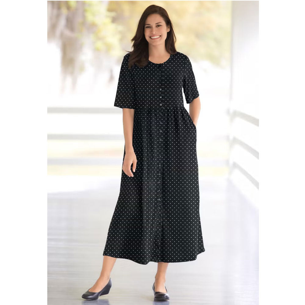 Woman wearing black polka dot button-front dress with gathered waist and flowing skirt