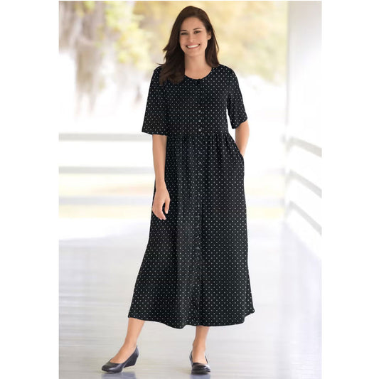 Woman wearing black polka dot button-front dress with gathered waist and flowing skirt